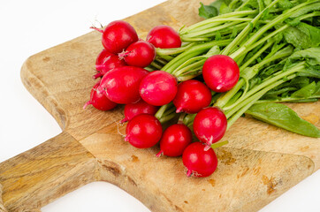 Bunch of fresh radishes on kitchen wooden cutting board. Studio Photo