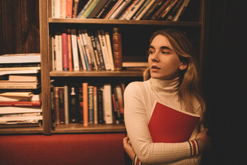 Serious woman with book in library