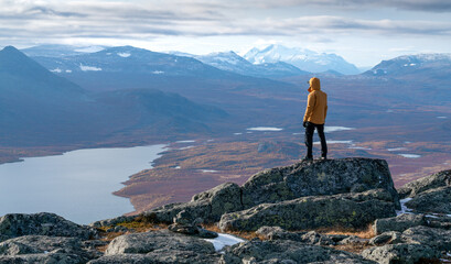 Randonneur mâle donnant sur une vue épique du vaste paysage arctique du parc national de Stora Sjofallet, en Suède, le jour de l& 39 automne. Montagnes et vallées de Laponie. Massif d& 39 Ahkka. Vue depuis le sommet du Lulep Gierkav.