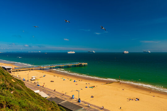 Boscombe beach and pier with cruise liners moored in Poole Bay
