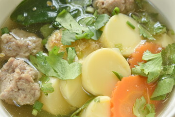 boiled vegetable gourd chop pork and carrot with egg tofu soup on bowl