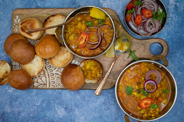Vegetarian indian pav bhaji board: mixed potato and vegetables curry with butter toasted bund and side dishes