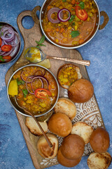 Fototapeta na wymiar Vegetarian indian pav bhaji board: mixed potato and vegetables curry with butter toasted bund and side dishes