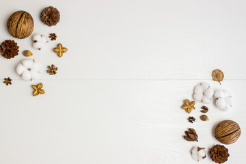 Cotton flowers. pine cones, and nature seed over the white wooden background.