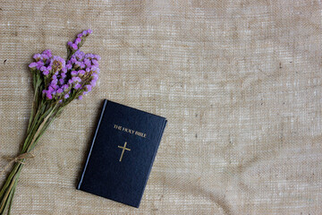 bouquet of flowers and a Bible over the brown fabric.