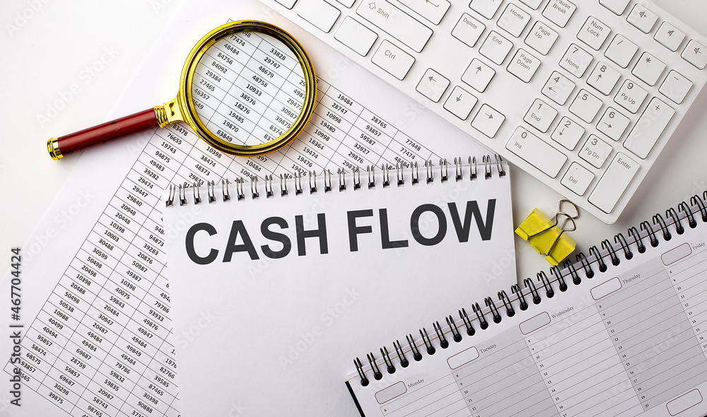 Poster cash flow text written on a notebook on chart with keyboard and planning