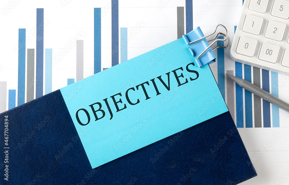 Poster objectives on sticky note on notebook on the chart background