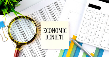 ECONOMIC BENEFIT text on sticker on diagram with magnifier and calculator. Business concept