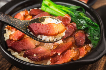 Cantonese style cooking of claypot rice with waxed meats
