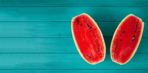 Watermelon sliced in a half on the wooden turquoise background. Red juicy summer fruit berry