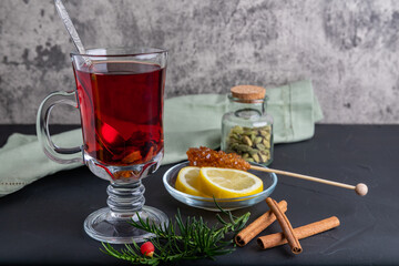Hot fruit tea with lemon on the dark surface, copy space