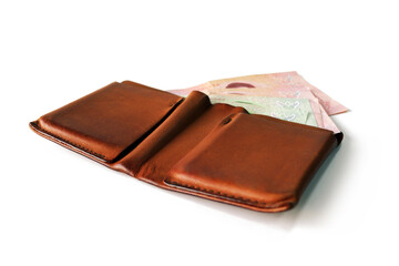 Several Thai banknotes in a brown wallet placed on a white background. Isolated.