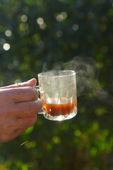 Male hand holding a mug with tea