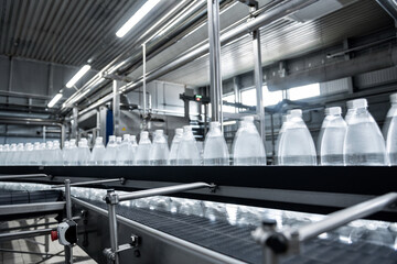 Conveyor belt with bottles of drinking water at a modern beverage plant.