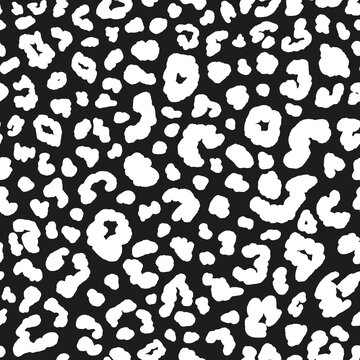Monochrome leopard seamless repeat pattern. Random placed, vector spots animal skin all over surface print on black background.