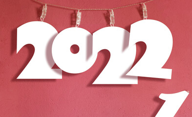 Mockup papercut 2022 sign hanging on a laundry string. New year replacing the old one concept. 