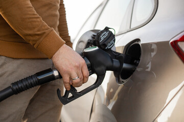 Car refueling on the petrol station. Hand refilling the car with fuel. Close up view. Gasoline,...