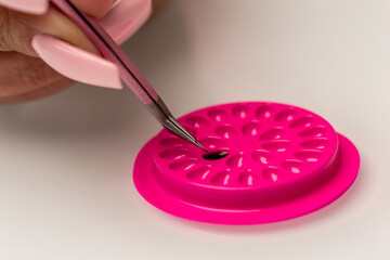 Eyelash extension tools. Fake eyelashes. Accessories for eyelash extensions. Drop of eyelash glue and curve tweezers. Eyelash extension procedure.