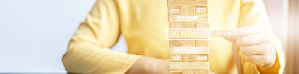 A woman plays a game of wooden blocks that are building blocks, she is picking up a block of wood...