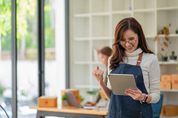 Beautiful young Asian woman excited looking at digital tablet computer smiling girl with touchpad 
