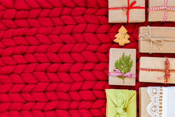 Christmas gifts kraft boxes with ribbons eco-friendly packages on red background. The concept of Christmas, New Year with copy space