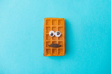 Viennese waffle with panic emoji smiley on blue background - Powered by Adobe