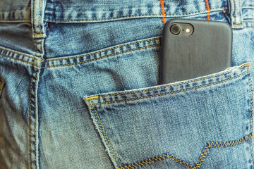 smartphone in back pocket of denim jeans close up