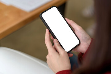 Close-up of a businesswoman hand holding a smartphone blank white screen enjoy social media applications ads. Mock up.