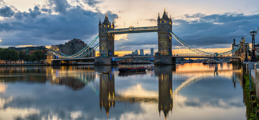 Tower Bridge at colourful sunrise with reflection in London. England