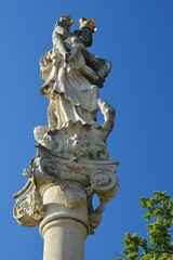 Baroque plague column in Skalica, Slovakia, with statiue of Virgin Mary with Child, built around year 1965. Summer clear blue skies, daylight sunshine.