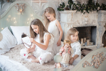 Little girls play in the bedroom in the morning before Christmas. Winter holidays, Christmas, New Year.