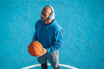 Sportsman standing in the stadium at the open air and holding orange ball while playing