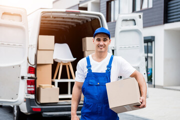 Removal company worker unloading boxes from minibus into customer's home