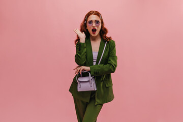Pretty caucasian young lady admires what she sees being in pink room. Red-haired beauty in glasses...