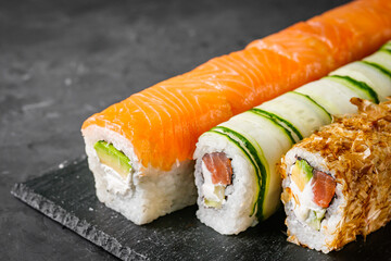 appetizing set of sushi roll on a black stone plate
