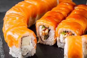 appetizing set of sushi roll on a black stone plate