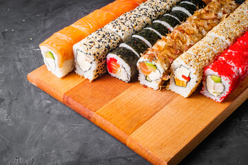appetizing set of sushi roll on a black stone plate