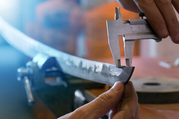 Katana sword making. Measuring control of kissaki blade thickness.