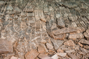 Stone texture seen through very clear and still water