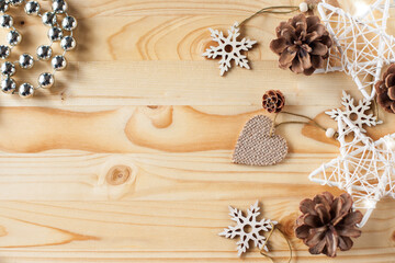 christmas background. Cones, stars and wooden figures in 
 snowflakes on a light wooden background