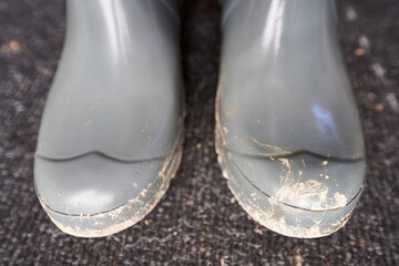 Schmutzige graue Gummistiefel