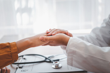 Close-up of the psychiatrist's hand holding the patient's hand. To encourage and comfort the patient.