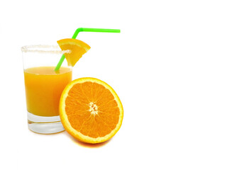Orange juice in a glass with a green straw and half an orange next to the glass isolated on a white background.