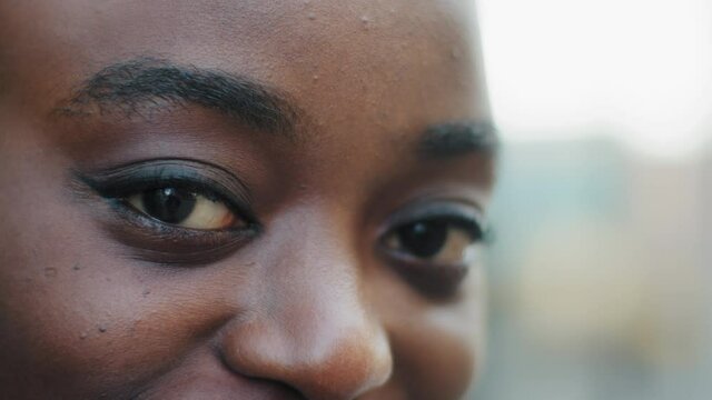 Close up female black face young afro american girl looking at camera with beautiful dark eyes, attractive african woman lady with good vision sight eyesight with long eyelashes make-up, ophthalmology