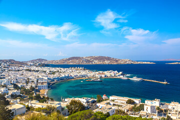 Fototapeta na wymiar Chora port of Mykonos island with red church, famous windmills, ships and yachts during summer sunny day. Aegean sea, Greece