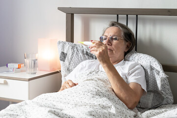 aging senior woman female bed home flat and tired sick ill alone retired resting virus, unhappy...
