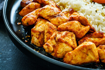 Fried chicken nuggets with white rice, brussels sprouts, carrots and tangerines on wooden table