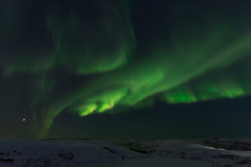At night in winter, the tundra and the aurora borealis.