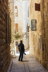 Fototapeta na wymiar Tourist photographer on the streets of the old city of Jerusalem
