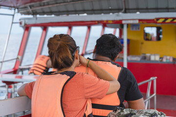 Back view of lover passengers in life vest relaxing on balcony enjoying view from boat of Samui...